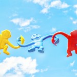 three assorted-color monkey plastic toys holding each other during daytime